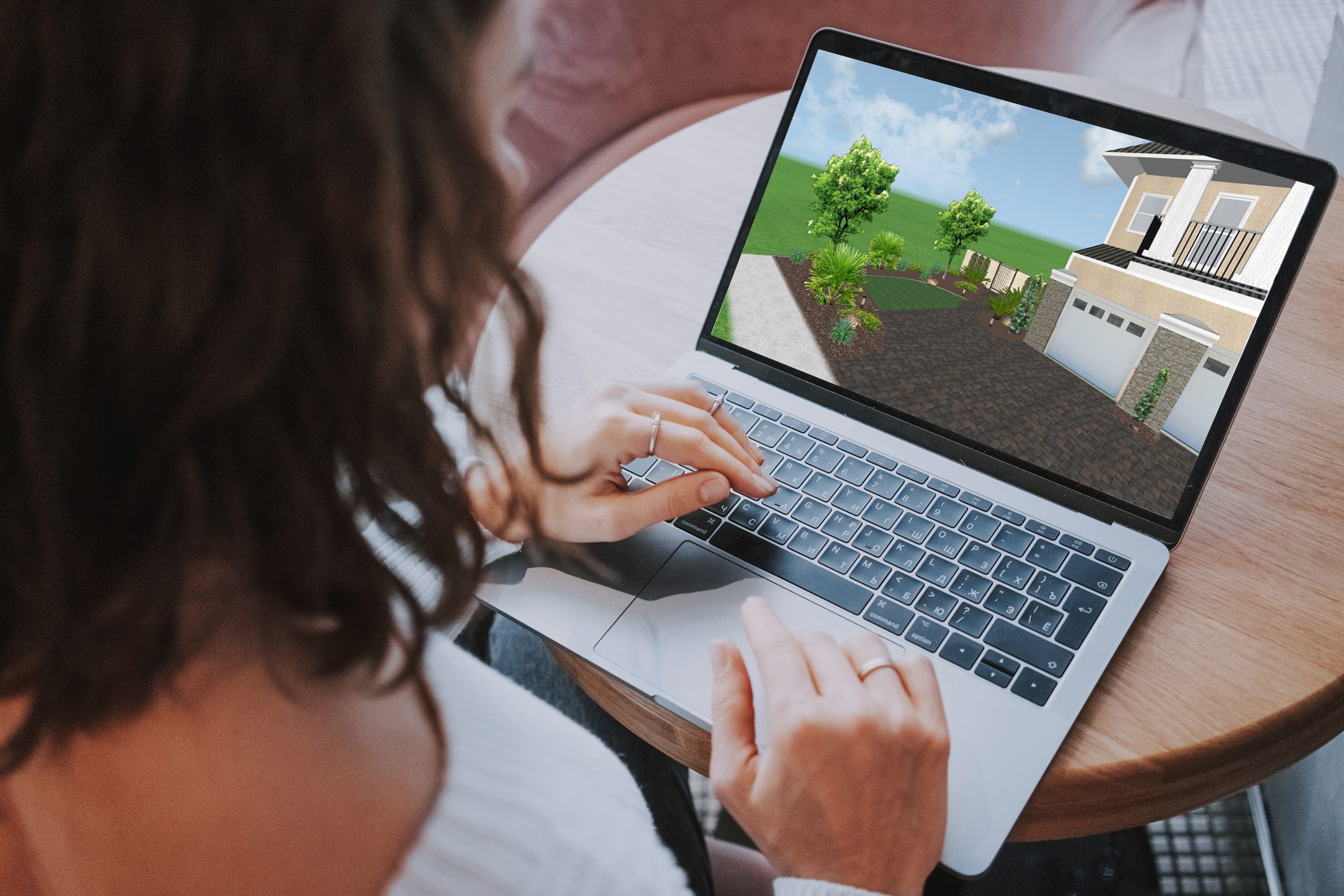 3D render of a front yard lawn in laptop from behind an unrecognizable woman